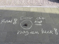 908130 Afbeelding van gemarkeerde hondendrol met rondom een waarschuwingstekst, op de stoep in de Schutstraat te Utrecht.